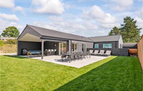 a house with a patio with chairs and a table at Gorgeous Home In Ebeltoft With Sauna in Ebeltoft