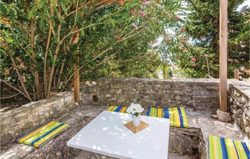 een witte tafel met twee stoelen en een vaas met bloemen bij Two-Bedroom Apartment In Krusevo in Kruševo