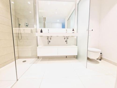a white bathroom with a sink and a toilet at higuerón Aqualis in Torremuelle