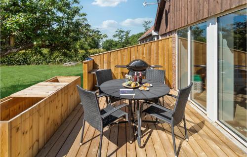 a patio with a table and chairs on a deck at Nice Apartment In Aakirkeby With Wifi in Åkirkeby