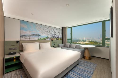 Un ou plusieurs lits dans un hébergement de l'établissement Holiday Inn Wuhan Riverside by IHG