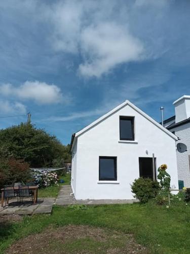 a white house with a bench in front of it at Glandore 2 bedroom house in Glandore
