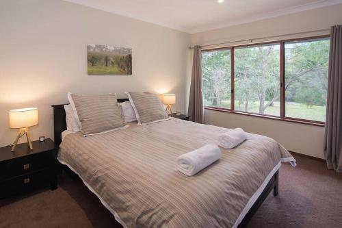 una camera da letto con un letto grande con due asciugamani sopra di Wilyabrup River Retreat- Flutes Estate, Margaret River a Wilyabrup