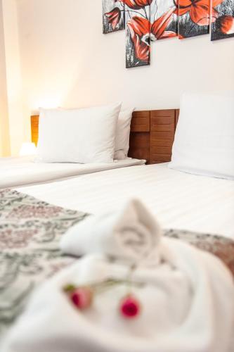 a bed with white sheets and red berries on it at Hotel Parc Sibiu in Sibiu