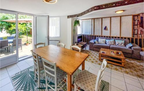 un salon avec une table et des chaises en bois dans l'établissement Stunning Home In Les Sables Dolonne, à Saint-Martin-de-Brem