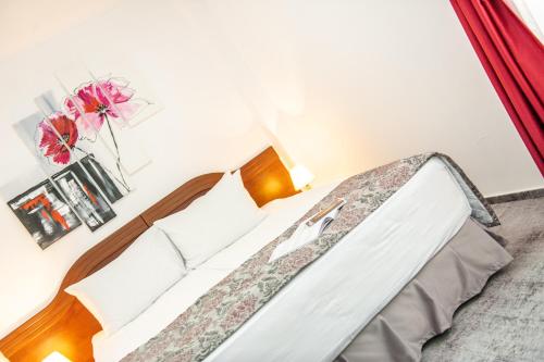 a bedroom with a bed and a vase with flowers at Hotel Parc Sibiu in Sibiu