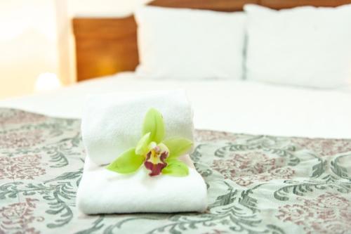 a towel with a flower on top of a bed at Hotel Parc Sibiu in Sibiu