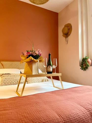 a bedroom with a bed and a table with wine glasses at Les secrets de la baie - La Romana - évasion relaxante hammam et Spa privatif in Étaples