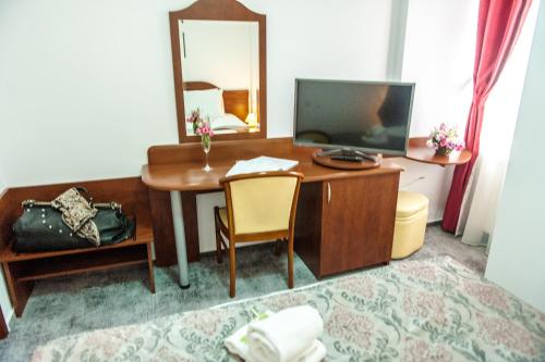 a hotel room with a desk and a television at Hotel Parc Sibiu in Sibiu