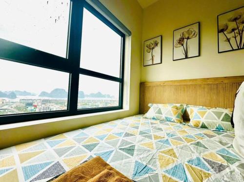 a bedroom with a bed and a large window at Apartment in Cam Pha city with amazing ocean view in Quang Ninh
