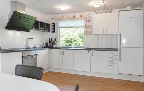a kitchen with white cabinets and a window at Amazing Home In Nexø With Wifi in Neksø