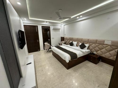 a bedroom with a large bed and a television at Hotel the royal Oakes in New Delhi
