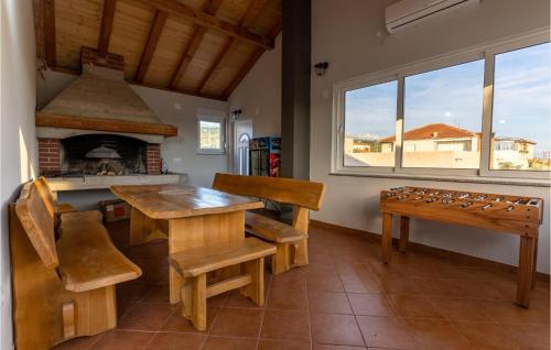 a dining room with a table and a fireplace at Cozy Home In Posedarje With Wifi in Posedarje