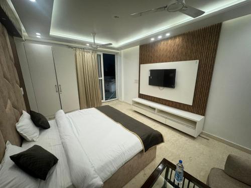 a bedroom with a bed and a flat screen tv at Hotel the royal Oakes in New Delhi