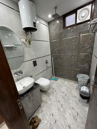 a bathroom with a sink and a toilet and a mirror at Hotel the royal Oakes in New Delhi