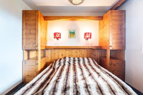 Ce lit se trouve dans un dortoir doté de murs en bois. dans l'établissement L'Ecrin des Sybelles - Apt piscine sauna partagés, à La Toussuire