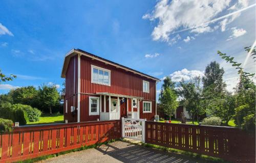 a red house with a fence in front of it at Stunning Home In Gnesta With Wifi in Gnesta