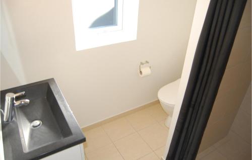 a bathroom with a sink and a toilet at 6 Bedroom Beautiful Home In Tranekær in Hou