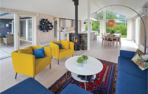 a living room with two yellow chairs and a table at Holiday Home Ebeltoft With A Fireplace 9 in Ebeltoft