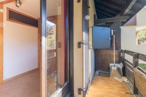 une porte en verre dans une chambre avec couloir dans l'établissement Génépi - Studio pour 5 vue montagne, à Vars