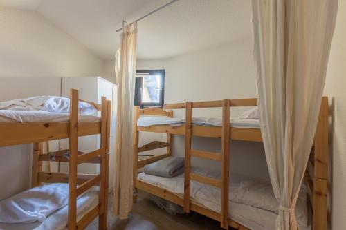 une chambre avec trois lits superposés dans une pièce dans l'établissement Faliju - appartement avec vue montagne, à Vars