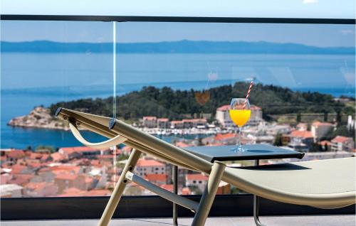 a glass of orange juice sitting on a table in front of a window at Villa Rhapsody 2 Aurelia 2 in Makarska