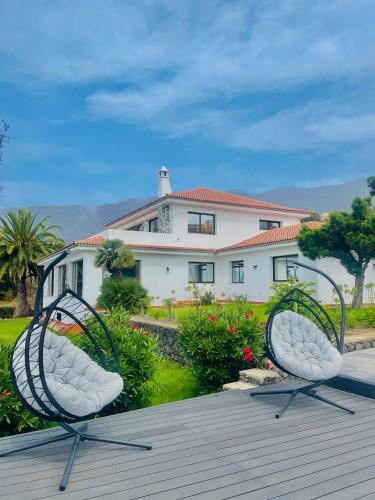 two chairs sitting on a deck in front of a house at Villa SOHLARA in La Orotava