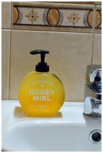 a yellow soap dispenser sitting on top of a sink at Color 24 Apartament VIII in Stalowa Wola