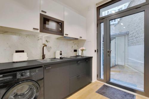 une cuisine avec une machine à laver et un évier dans l'établissement Stunning apartment 2BR Opera, à Paris
