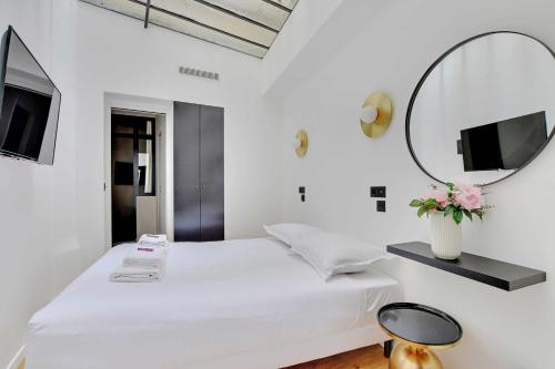 - une chambre blanche avec un lit blanc et un miroir dans l'établissement Stunning apartment 2BR Opera, à Paris