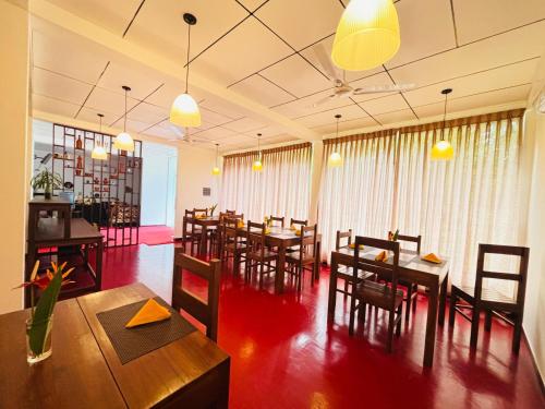 a restaurant with wooden tables and chairs and lights at Forest Dew Udawalawa in Udawalawe