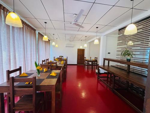 a dining room with wooden tables and chairs at Forest Dew Udawalawa in Udawalawe