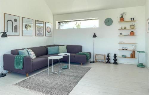 Una sala de estar con un sofá morado y una mesa. en Beautiful Home In Allinge With Kitchen, en Allinge