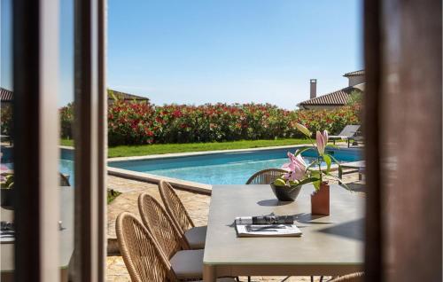 - une table et des chaises à côté de la piscine dans l'établissement Villa Megi, à Sveti Lovreč Pazenatički