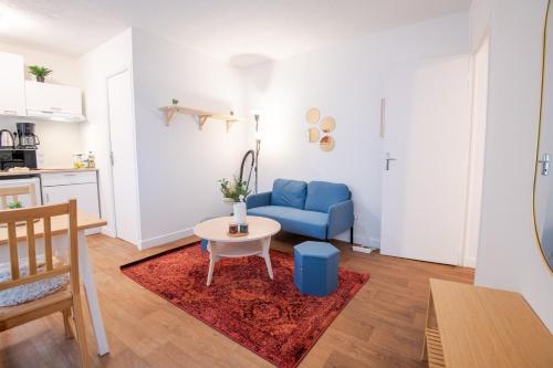 un salon avec un canapé bleu et une table dans l'établissement L Ecrin Amboisien, à Amboise