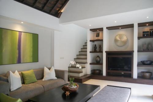 a living room with a couch and a tv at The Amala Boutique Retreat in Seminyak