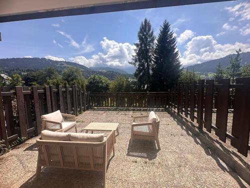 a patio with two chairs and a couch and a table at Studio Cosy cœur de Megève Le Soleil Levant in Megève