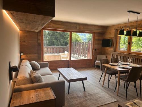 a living room with a couch and a table at Studio Cosy cœur de Megève Le Soleil Levant in Megève