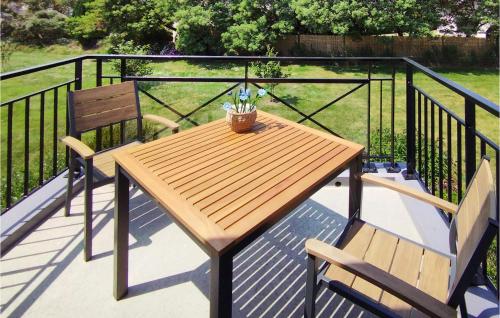 une table en bois et deux chaises sur un balcon dans l'établissement 1 Bedroom Lovely Apartment In Carantec, à Carantec