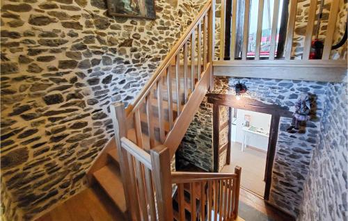 a wooden staircase in a stone building with a stone wall at 6 Bedroom Lovely Home In Tréguier in Tréguier