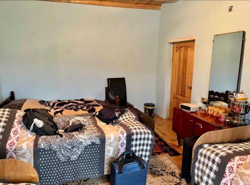 a bedroom with two beds and a desk and a mirror at Xinaliq Khinalig İzzet's Riverside Home Stay in Xınalıq