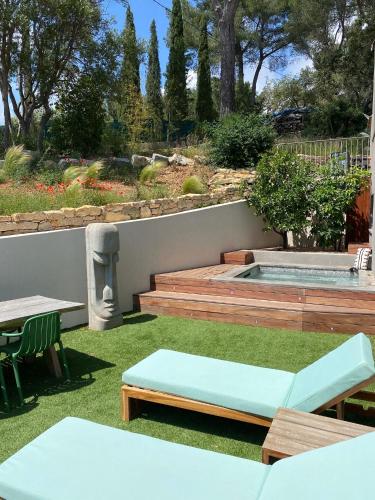 un jardin avec une table et des bancs et une piscine dans l'établissement Villa Bellysouh, à Sanary-sur-Mer