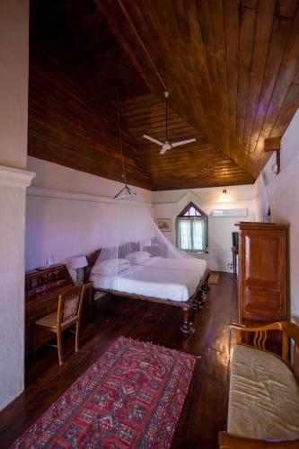 a bedroom with a bed and a desk and a rug at Old Courtyard Hotel in Cochin