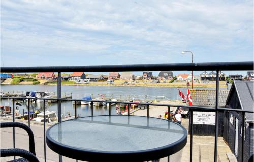 a table on a balcony with a view of a body of water at Holiday Home Havnevej Ulfborg Ix in Thorsminde