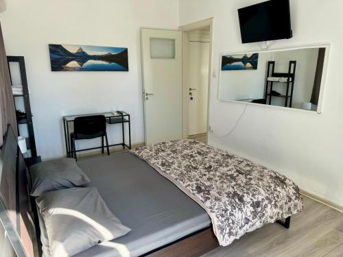 a bed in a room with a tv on a wall at Starfish Seaside Studio in Artemida