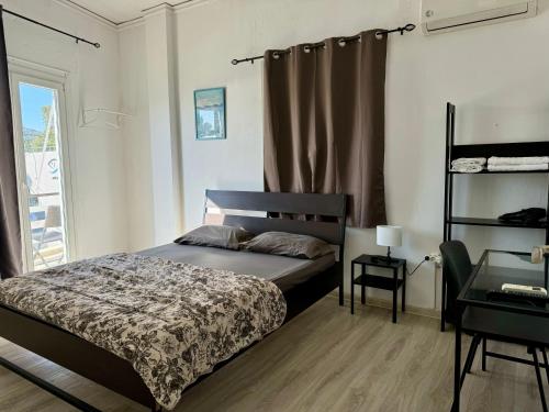 a bedroom with a bed and a window at Starfish Seaside Studio in Artemida