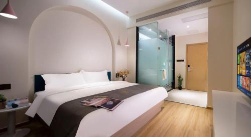 a bedroom with a large white bed with a glass door at 小鹿辰客觅度设计民宿 in Luoyushangcun