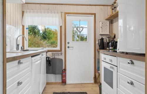 a kitchen with white cabinets and a white door at Nice Home In Bogø By With Wifi in Bogø By
