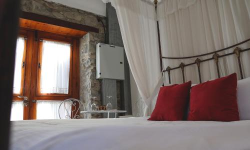 a bedroom with a large bed with red pillows at Vasilikis House in Kalopanayiotis