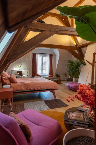 a bedroom with a large bed and a room with ceilings at Maison Brunon in Bruges